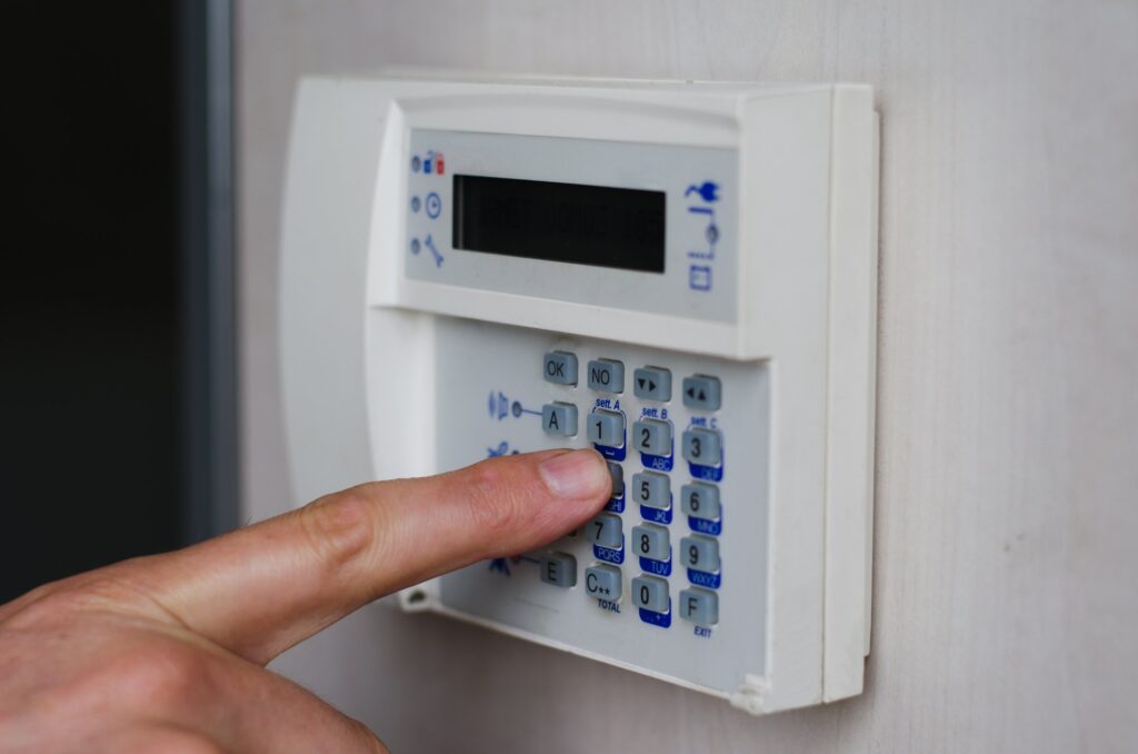 finger pressing keys on alarm keypad 180033659 2129x1410